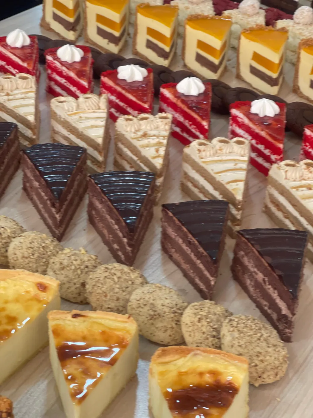 Trays of cake slices: red velvet, chocolate and cheesecake
