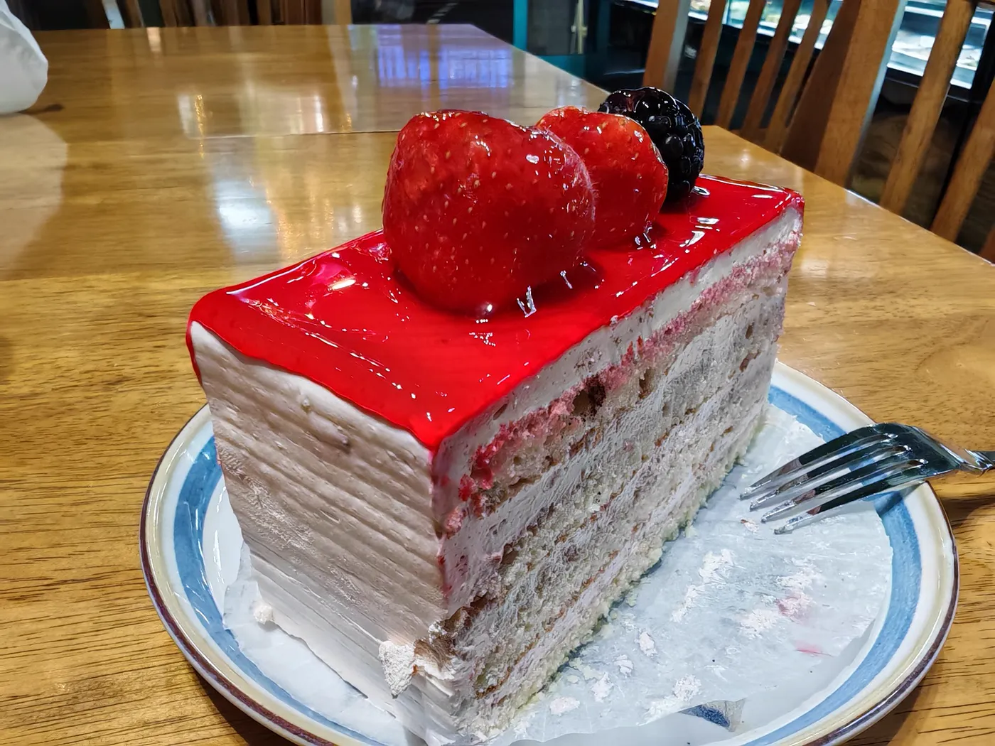 Slice of strawberry layer cake with fresh strawberries